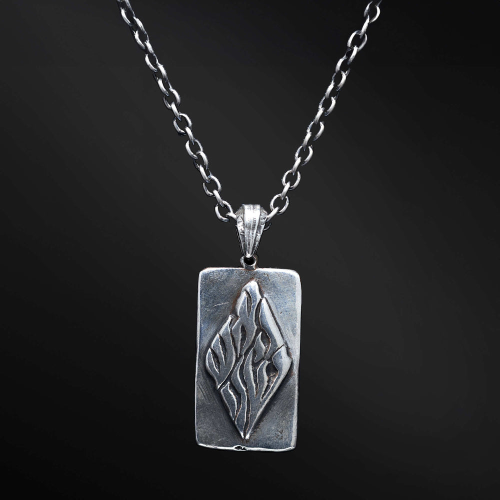 "Elkana Pendant: Unleash the power of your inner flame with the captivating Elkana pendant. Its elegant design showcases the phrase 'Aesh Sheli' engraved on a sleek plaque, representing the fire that resides within. Let its presence serve as a constant reminder of your inner strength, passion, and resilience as you navigate life's journey."