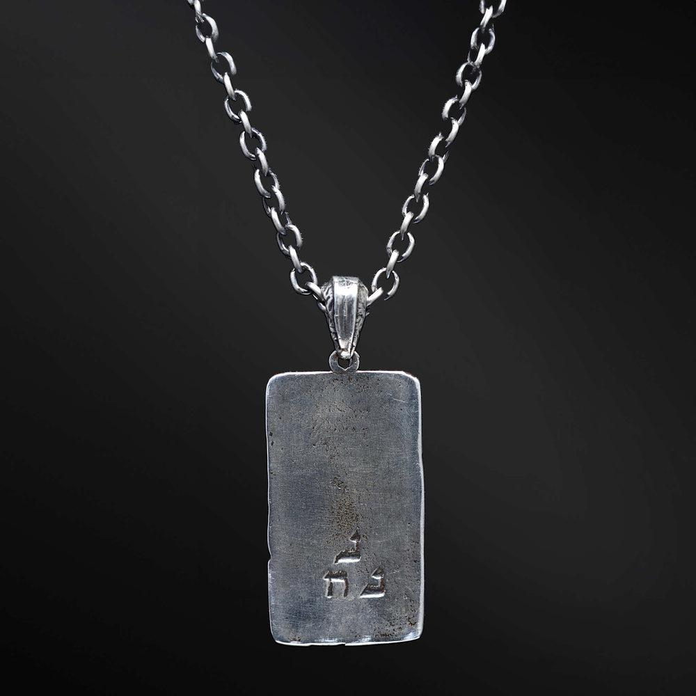 "Elkana Pendant: Unleash the power of your inner flame with the captivating Elkana pendant. Its elegant design showcases the phrase 'Aesh Sheli' engraved on a sleek plaque, representing the fire that resides within. Let its presence serve as a constant reminder of your inner strength, passion, and resilience as you navigate life's journey."