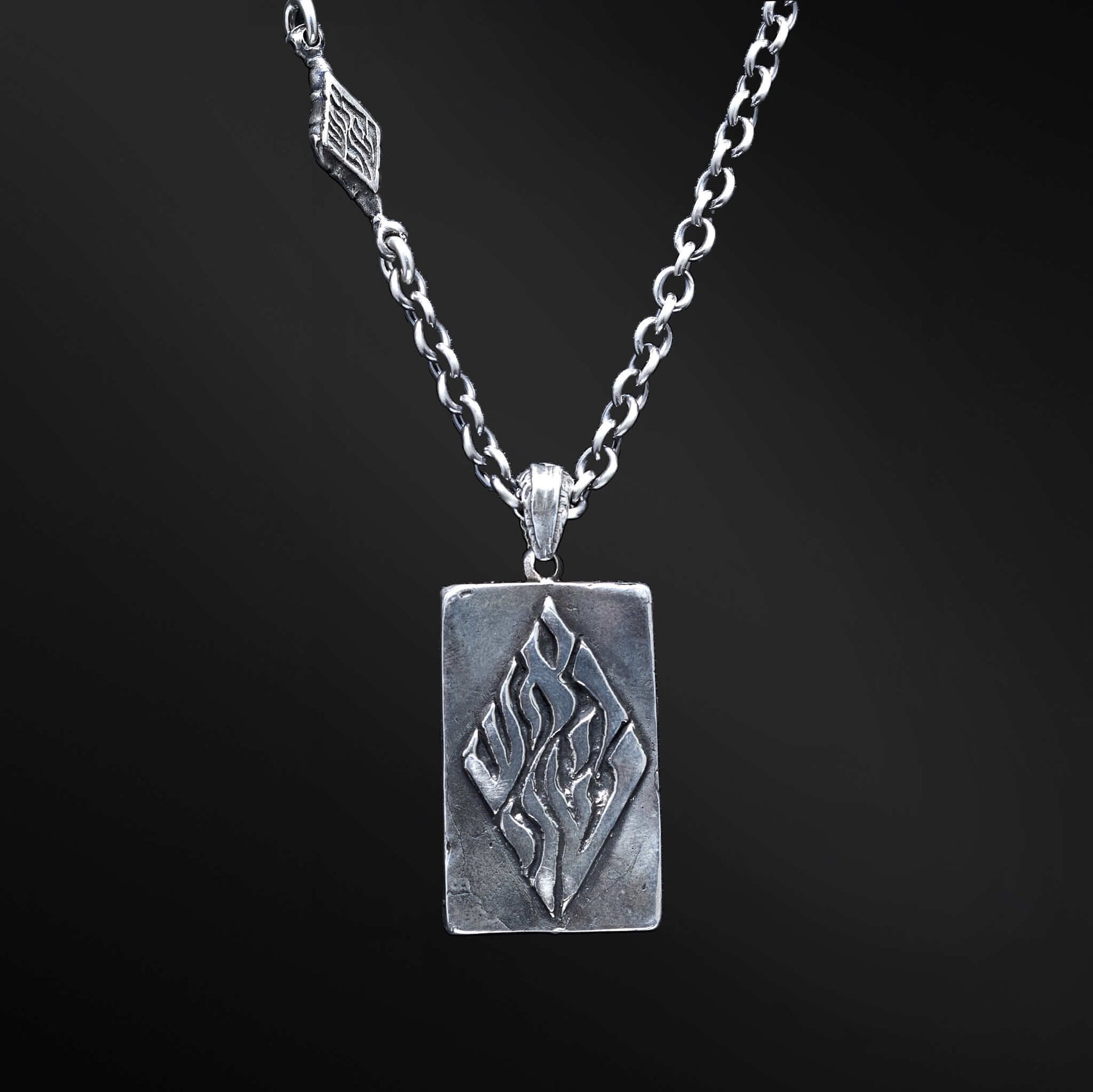 "Hidai Pendant: A collection of captivating images showcasing the fiery essence of the Hidai pendant. Engraved with the empowering words 'Aesh Sheli' (My Fire), it serves as a catalyst for passion and confidence. The precision craftsmanship of the square pendant radiates elegance and uniqueness, symbolizing your own distinct journey. Let these photos ignite your inner flame and empower you to shine boldly, embracing your true essence."