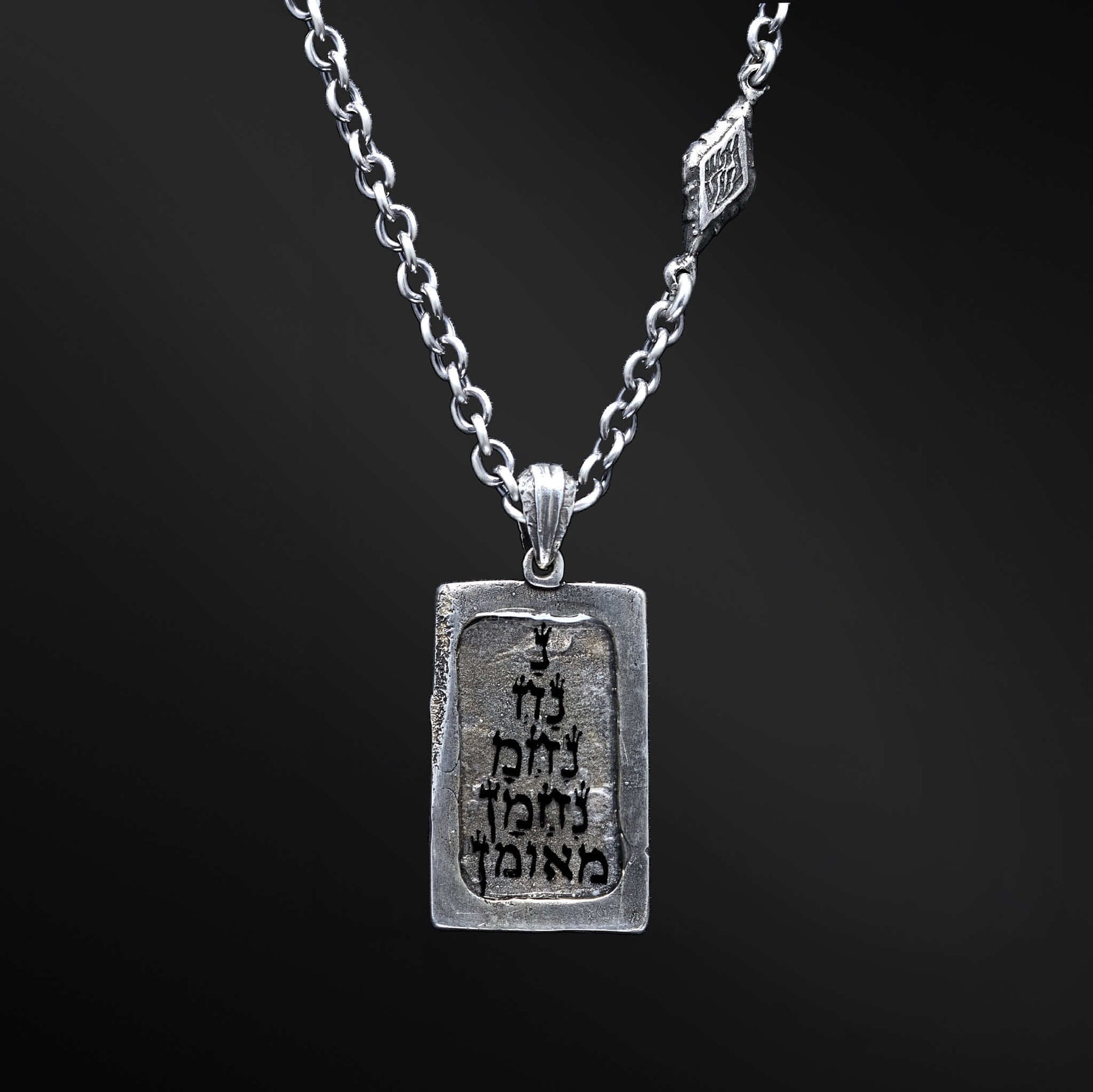 "Hidai Pendant: A collection of captivating images showcasing the fiery essence of the Hidai pendant. Engraved with the empowering words 'Aesh Sheli' (My Fire), it serves as a catalyst for passion and confidence. The precision craftsmanship of the square pendant radiates elegance and uniqueness, symbolizing your own distinct journey. Let these photos ignite your inner flame and empower you to shine boldly, embracing your true essence."