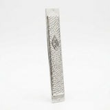 Hammered silver mezuzah plaque with Aesh Sheli flame emblem, angled view showing texture and thickness, handmade in Israel, Kameart