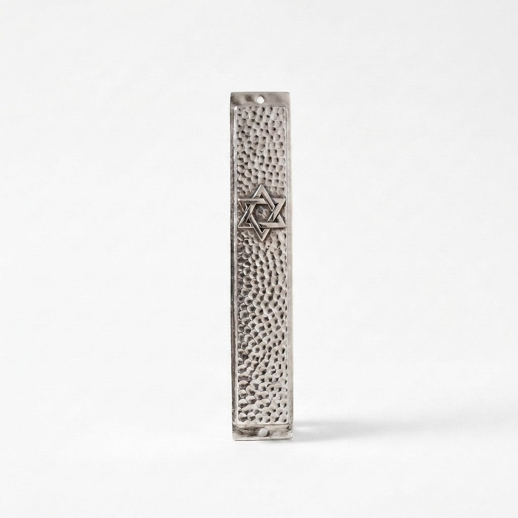 Close-up of hammered silver mezuzah case with engraved Star of David detail, handmade in Israel, Kameart