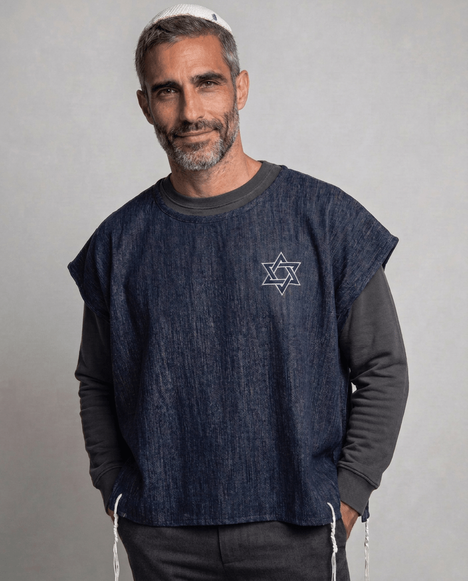 Man wearing tallit katan in denim with Magen David embroidery and white tzitzit, Kameart
