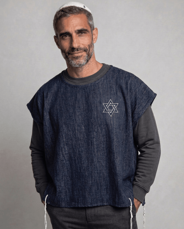 Man wearing tallit katan in denim with Magen David embroidery and white tzitzit, Kameart